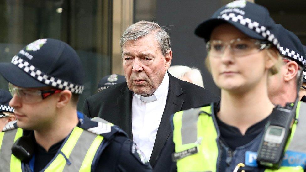 Cardinal George Pell leaves a Melbourne court on 2 May flanked by a police guard