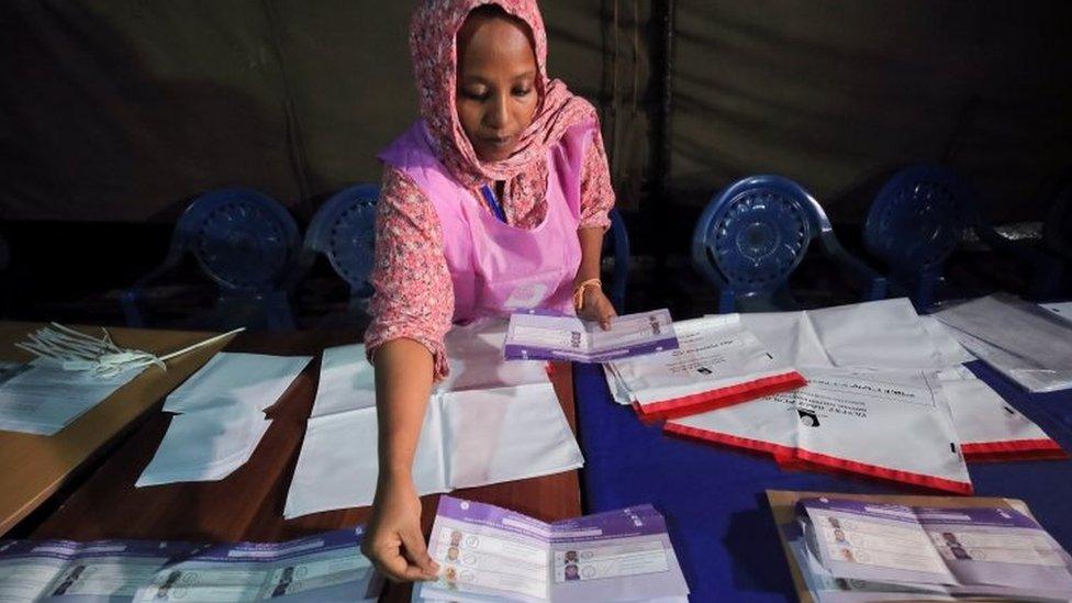 An election official counts voting ballots