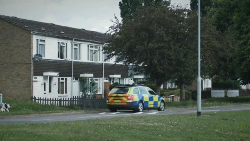 70s/80s estate with police car parked on the road