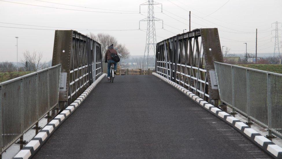 A cyclist on a bridge outside Fishlake