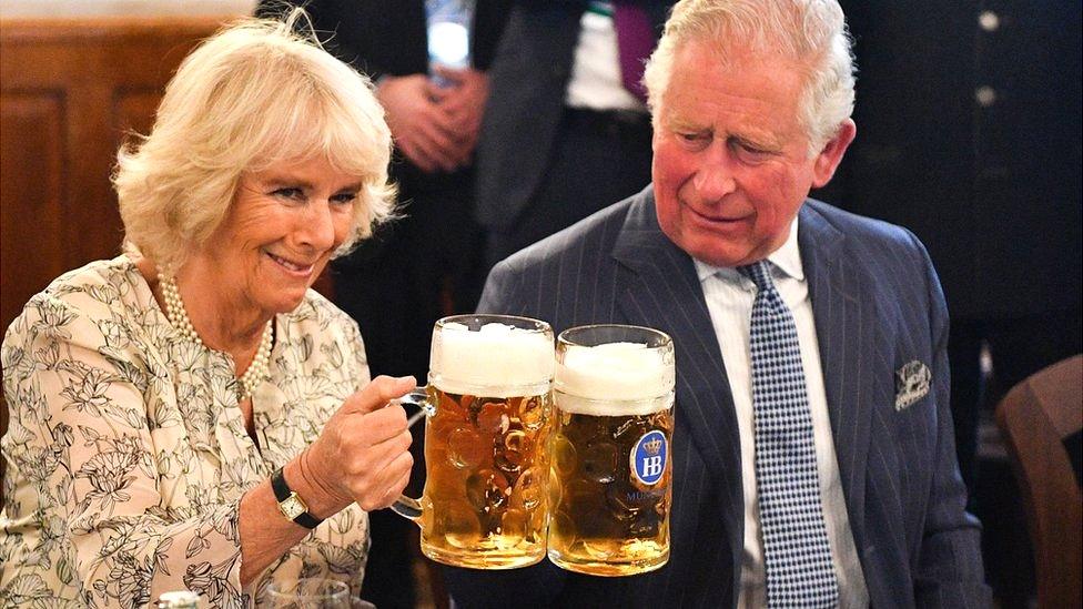 Camilla and Charles holding steins of beer in Germany in 2019