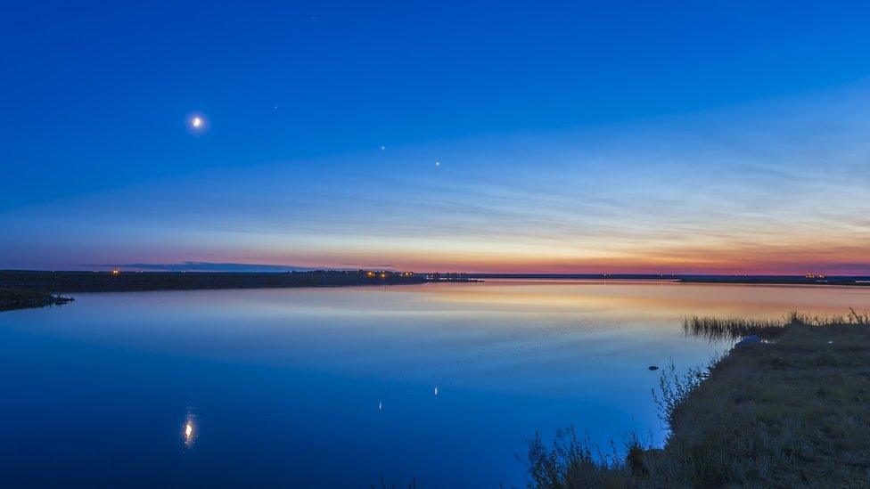 The evening planets of Venus (right) and Jupiter (left), to the right of the waxing crescent Moon on the evening of summer sosltice in 2015.