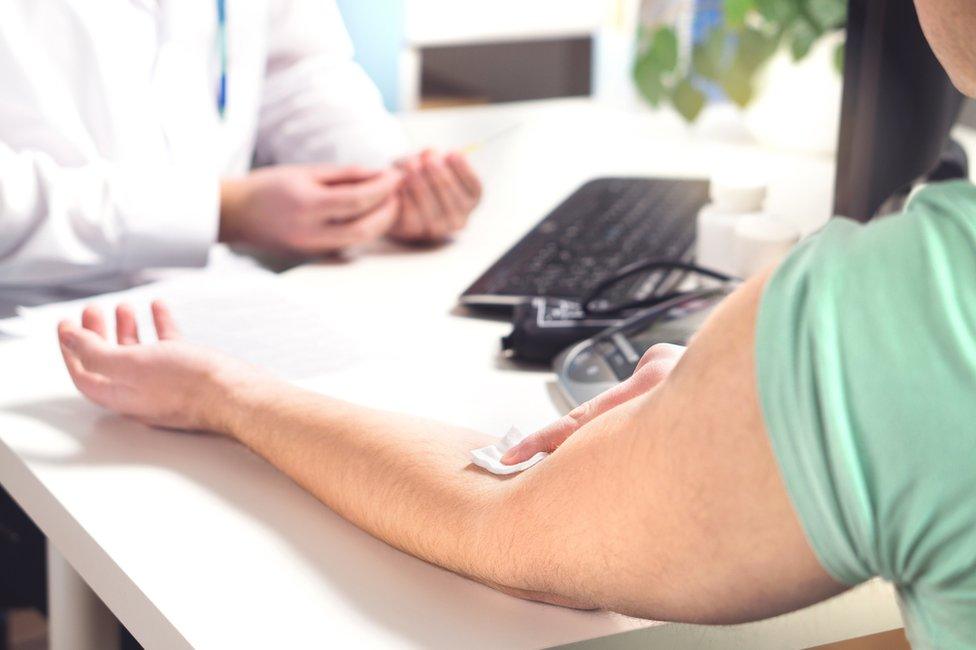 Man holding arm after blood test