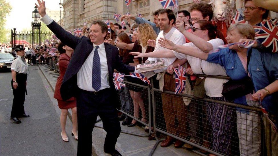 Newly elected British Prime Minister Tony Blair (C) waves at supporters 02 May upon his arrival at No 10 Downing Street