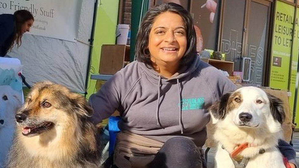 Poonam Doshi with two dogs by a charity stall