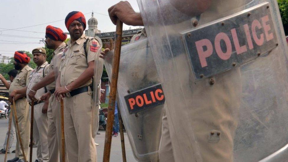 Indian police stand guard during a protest by Sikh demonstrators in Amritsar on October 19, 2015.