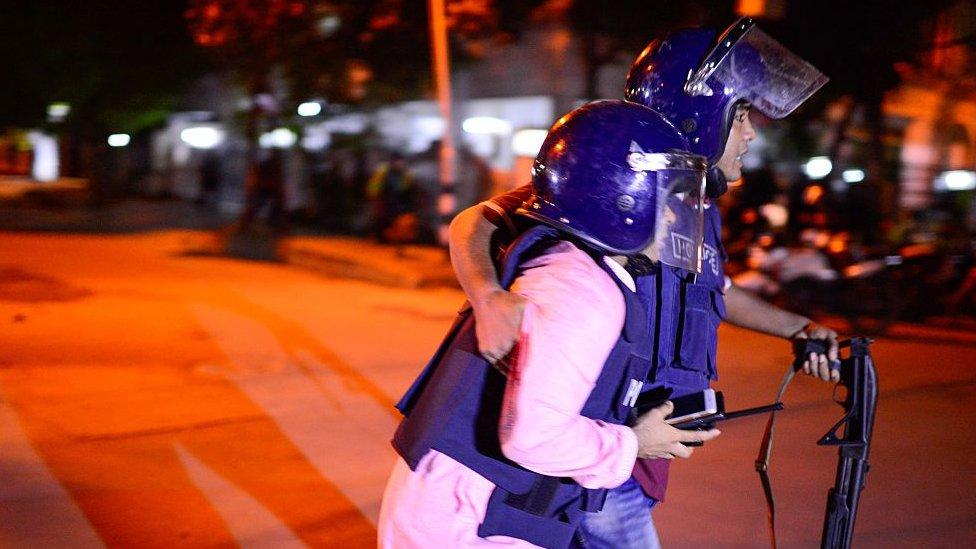 A Bangladeshi policeman that was injured during an attack on an upscale restaurant is helped by a colleague in Dhaka on July 1, 2016.