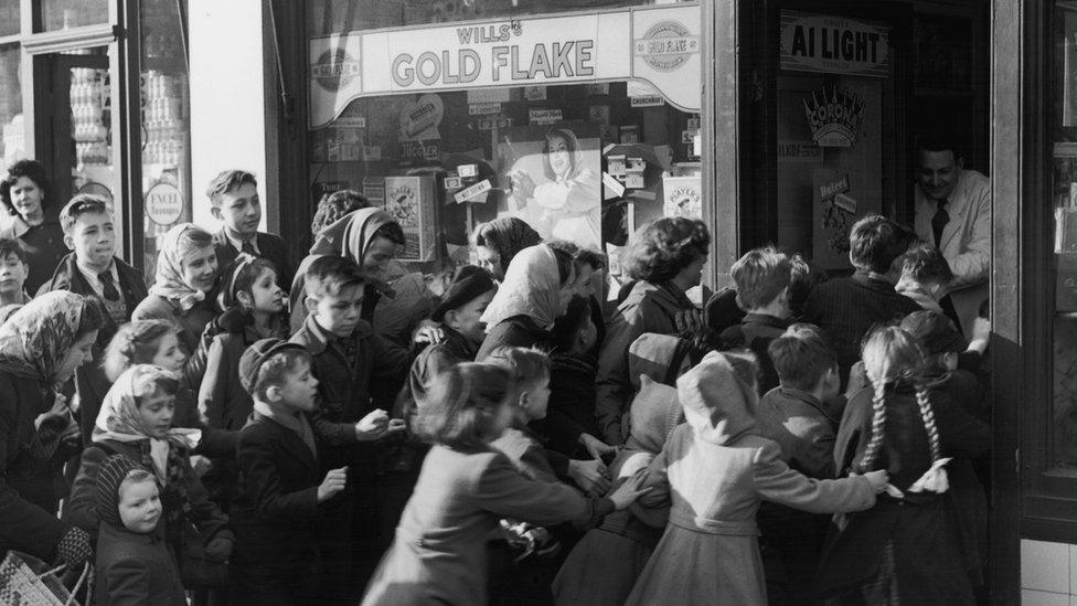 5th February 1953: A crowd of children rush to get into a sweetshop in north Acton as it opens its doors on the day sweet rationing ended.