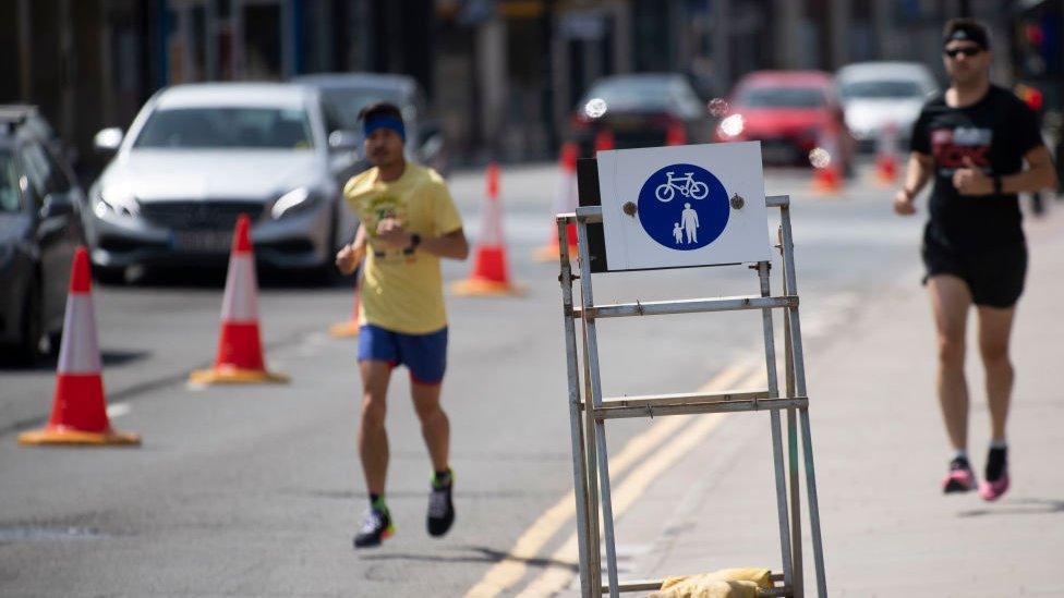 Two people running at a social distance near Cardiff Castle