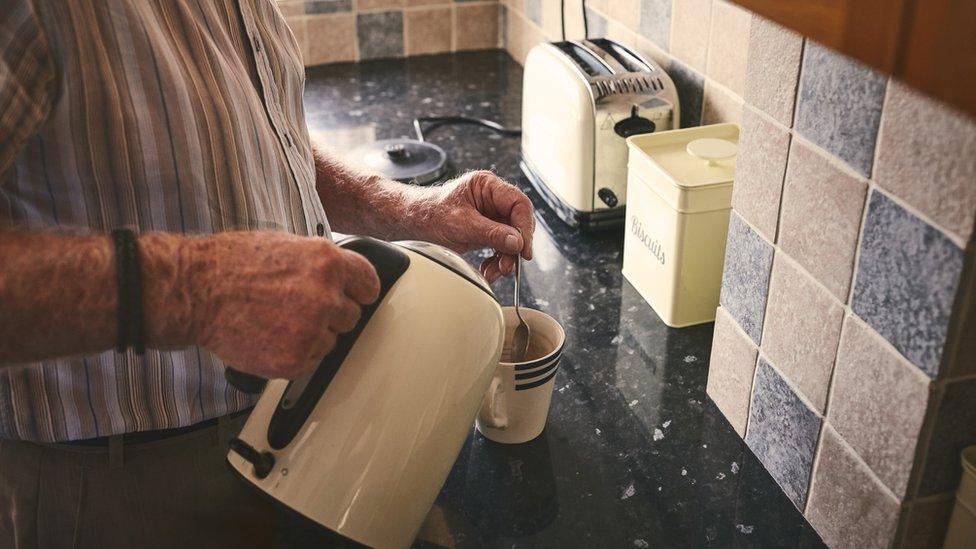 Stock old man making tea