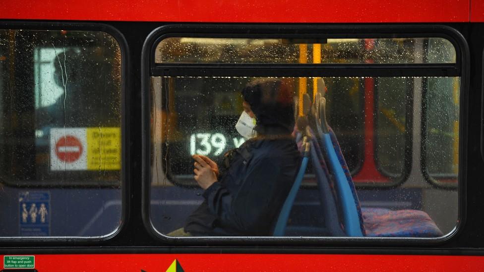 A commuter in a face mask on a London bus