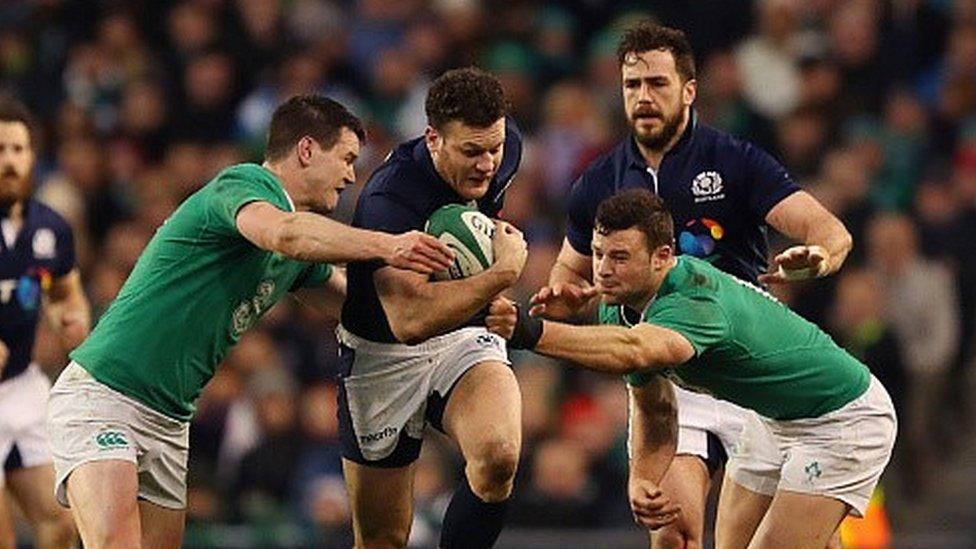 Duncan Taylor takes the ball up for Scotland as Alex Dunbar looks on