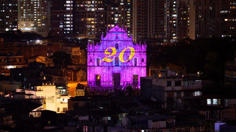 The number 20 is projected onto the ruins of St Paul