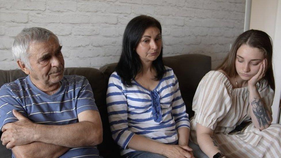 A man and two women sitting on a sofa