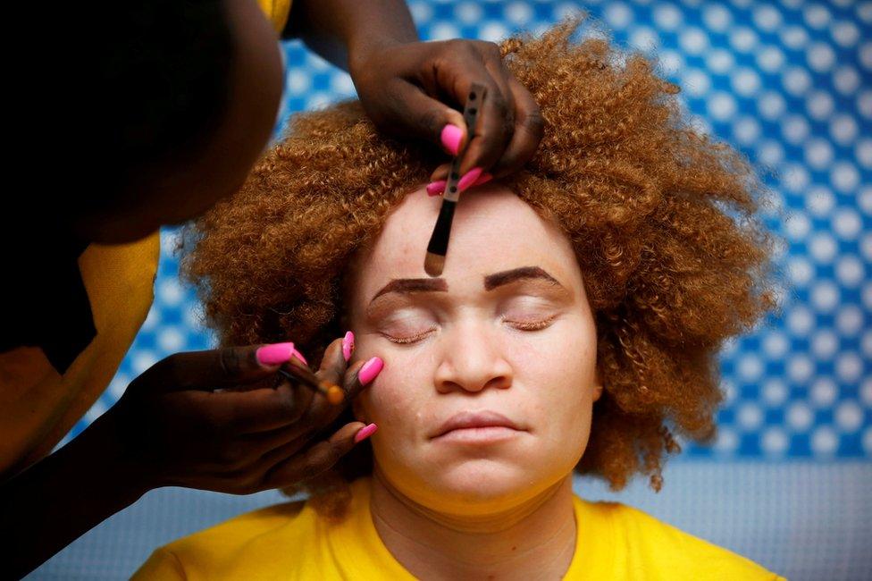 A make up artist works on a participant