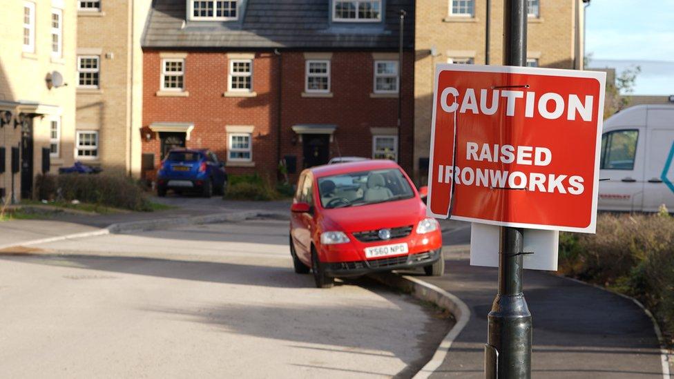 A sign warning of raised ironworks