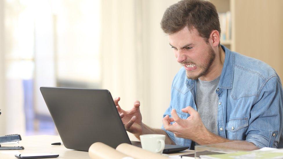 Frustrated man angry at laptop