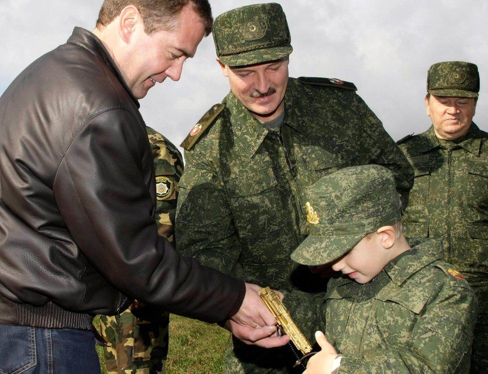 Russian President Dmitry Medvedev (left) and his Belarusian counterpart Alexander Lukashenko (C) interact with Lukashenko's five-year-old son Kolya at the Obuz-Lesnovsky firing range near Baranovichi in September 2009