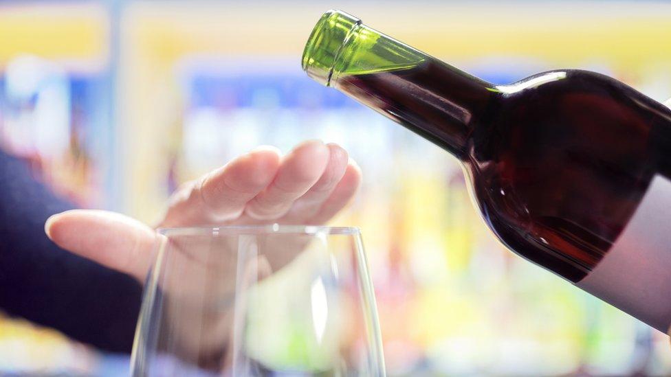 Woman's hand stopping wine being poured