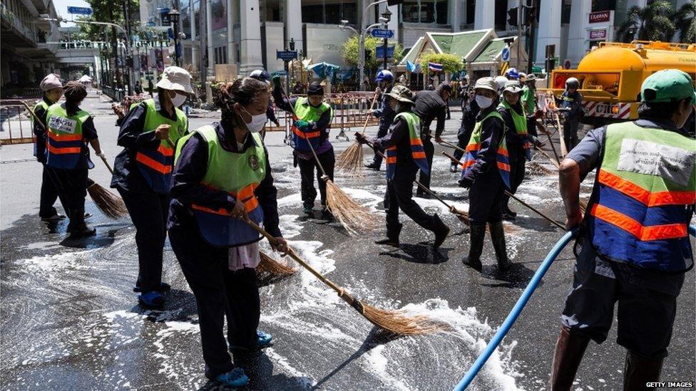 Workers clean up debris from the site of the explosion on 18 August 2015 in Bangkok, Thailand