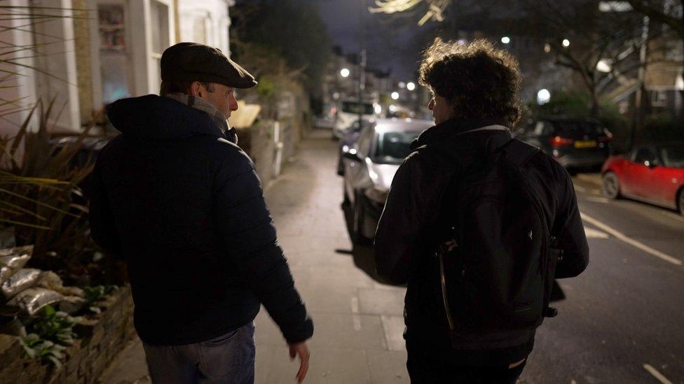 Tom Edwards and John Casey walking down a London pavement at night