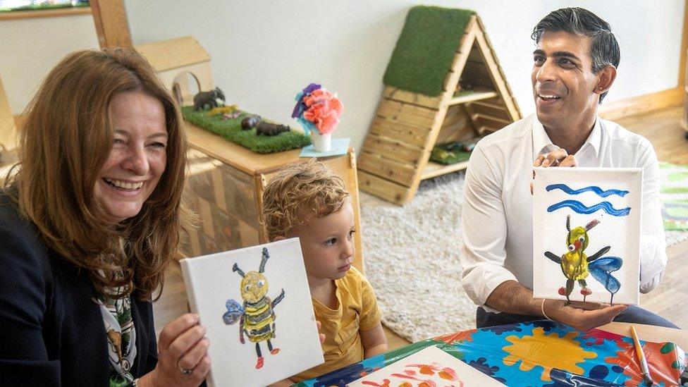 British Prime Minister Rishi Sunak and Education Secretary Gillian Keegan hold images of bees they created during a visit to the Busy Bees nursery in Harrogate