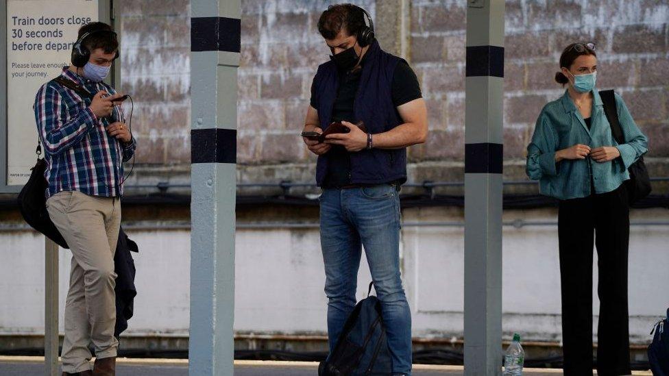 Masked passengers waiting for trains