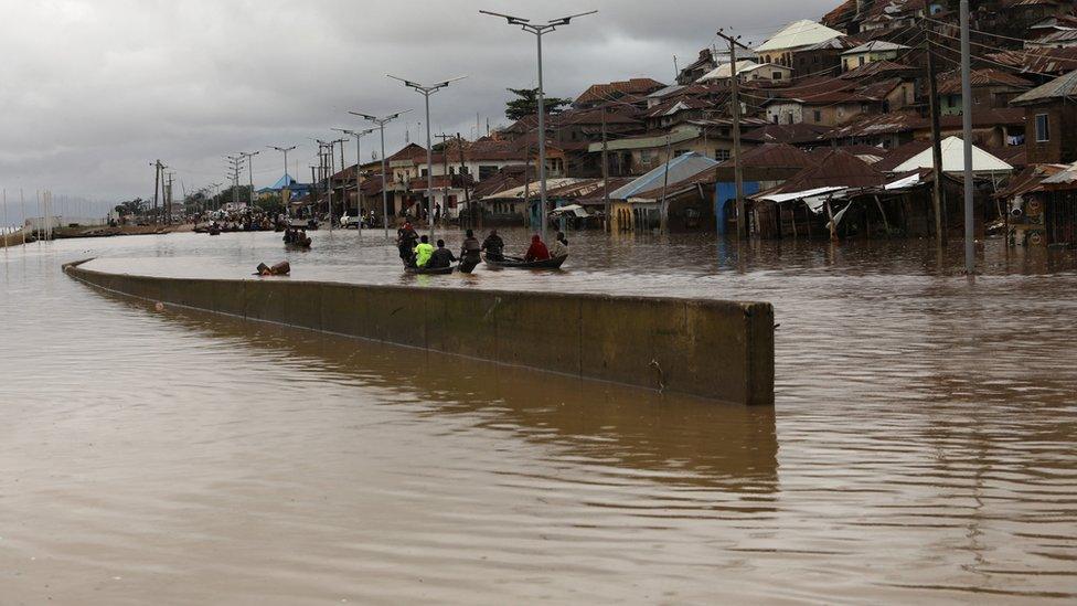 Flooding can be seen, and people in boats