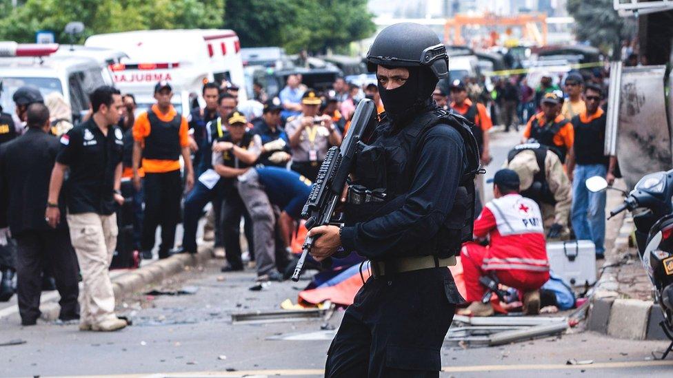 An Indonesian policeman stands guard in front of a blast site at the Indonesia capital Jakarta on January 14, 2016