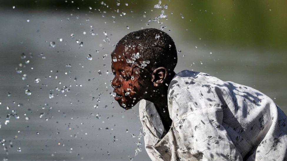 A boy splashes himself with water in the Atbarah river near the village of Dukouli within the Quraysha locality, located in the Fashaqa al-Sughra agricultural region of Sudan's eastern Gedaref state on March 16, 2021. - The decades-old border dispute over the Fashaqa fertile farmland region, sandwiched between the Atbarah and Setit (or Tekeze) rivers, and where Ethiopia's northern Amhara and Tigray regions meet Sudan's eastern Gedaref state, dates back decades, feeding regional rivalry and even sparking fears of broader conflict. With the zone contested, the exact area is not clear, but Fashaqa covers some 12,000 square kilometres (4,630 square miles), an area claimed by both Sudan and Ethiopia.