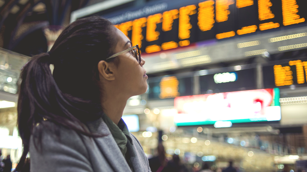 Rail passenger looks at departure board