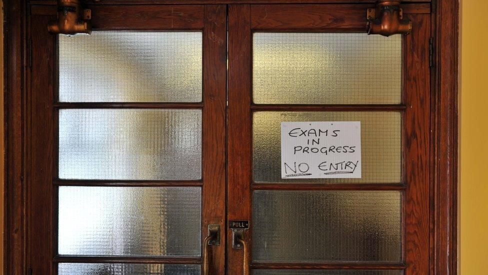 A sign on a door (reading: Exams in progress) outside an examination room