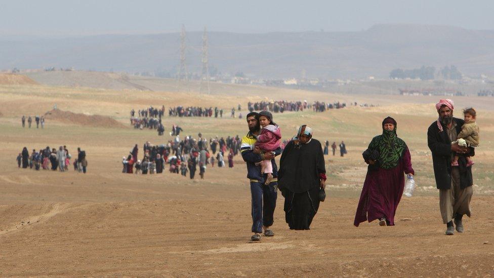 People flee their homes as Iraqi forces battle with so-called Islamic State (IS) in the village of Badoush, northwest of Mosul, Iraq, 11 March 2017