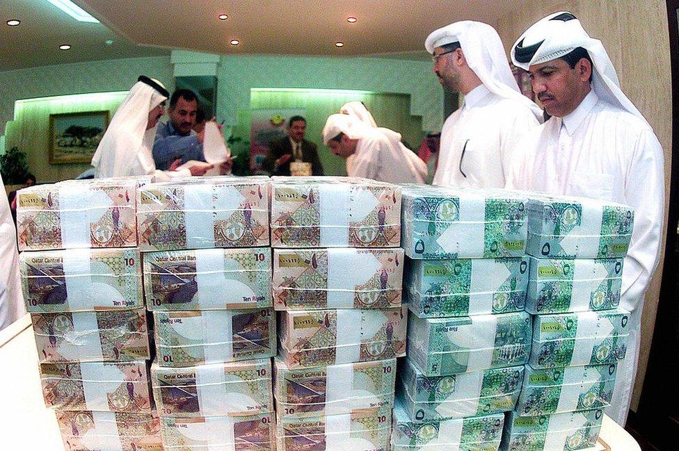 Officials from the Qatar Central Bank count cash