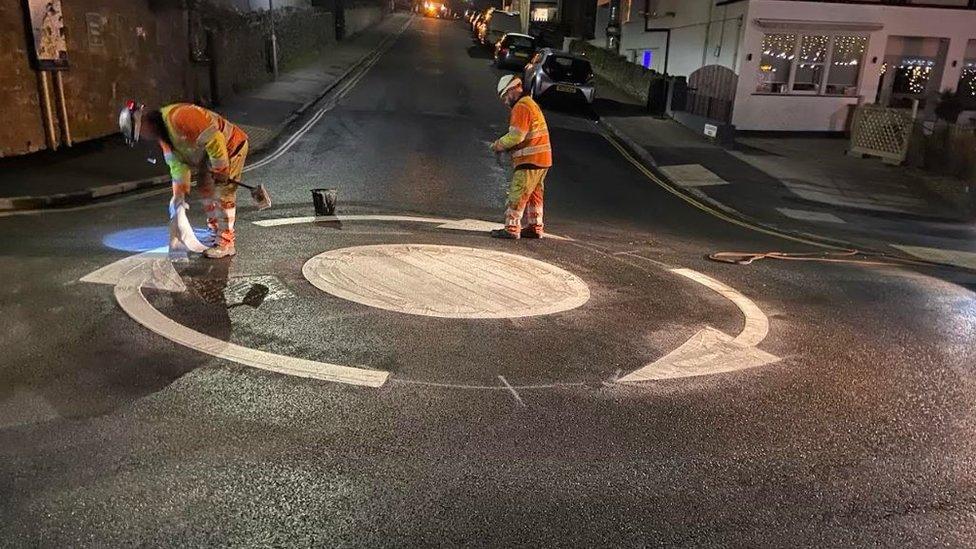 Workers painting a roundabout