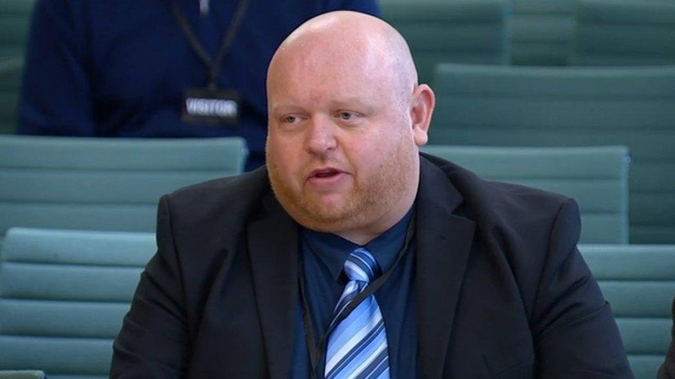 Alistair Jones, of the Action for Albion group, sitting at the Culture, Media and Sport Committee. He is bald and has a ginger beard and is wearing a blue, stripy tie