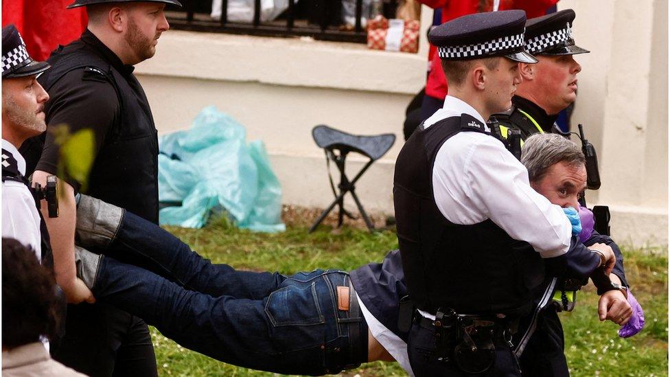 Police officers detain a member of Just Stop Oil