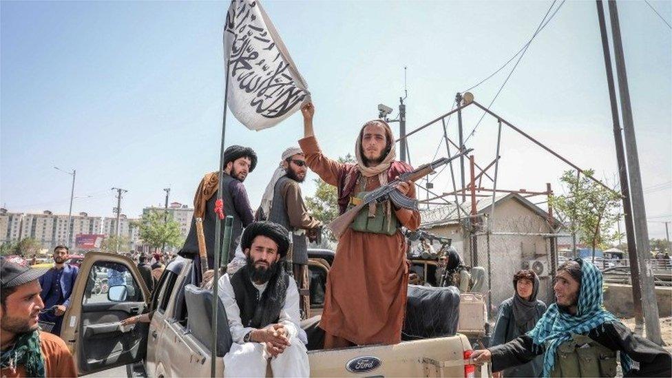 Taliban fighters are seen on the back of a vehicle in Kabul, Afghanistan, 16 August 2021