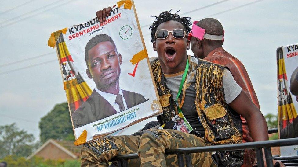 Bobi Wine's supporter holds his campaign poster