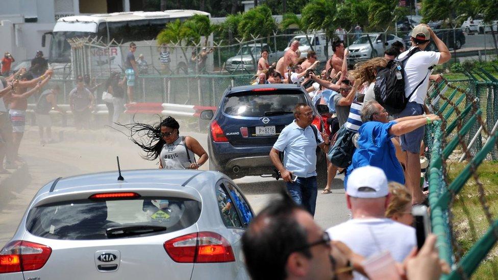 Image of people watching planes take off in Sint Maarten, taken at Maho Beach