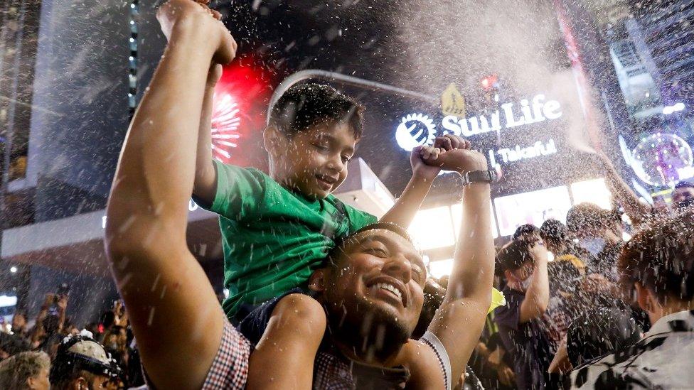 A man celebrates New Year's Eve with a kid in Kuala Lumpur, Malaysia January 1, 2023.