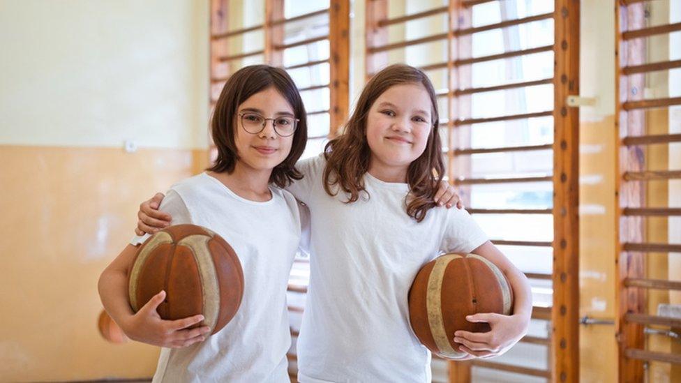 two girls in PE, smiling