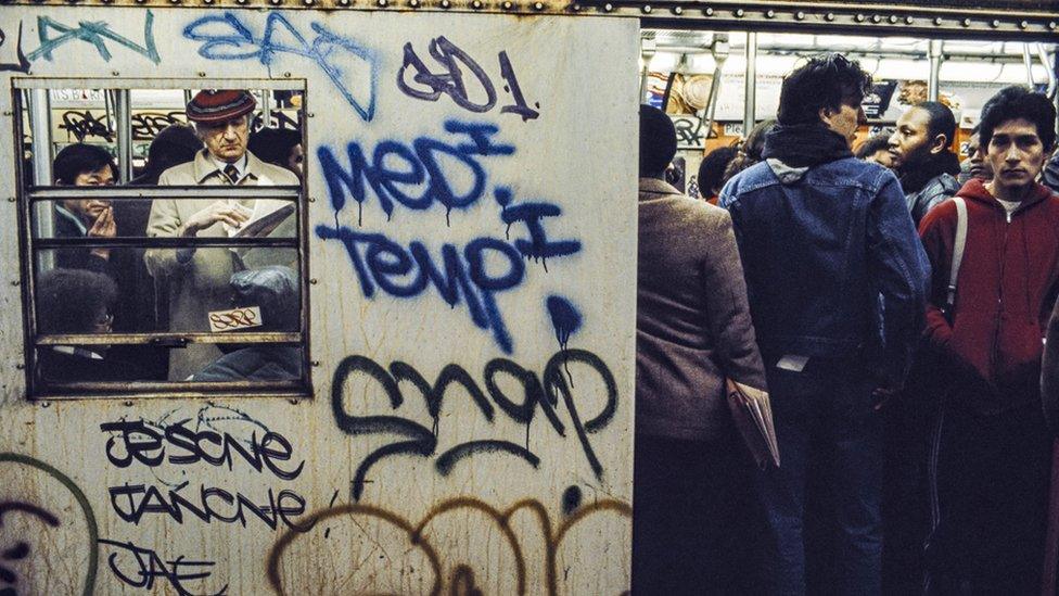 People on a New York Metro train in the early 1980s