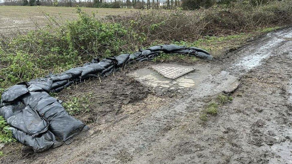 Sandbags around manhole cover