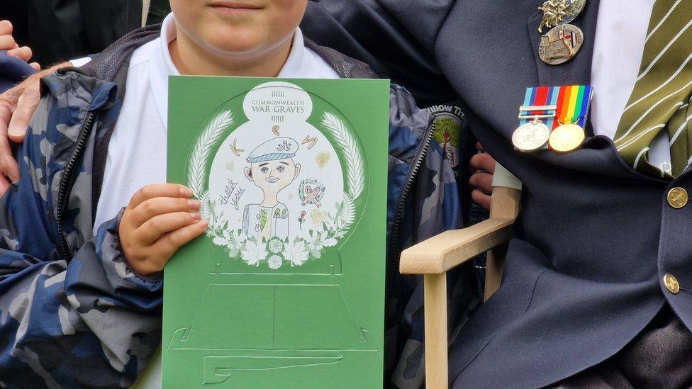 Child with picture of veteran Ken Cooke