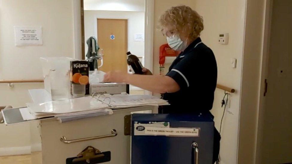 Care home nurse with medication trolley