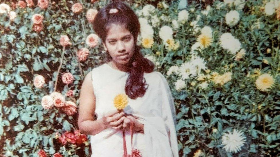 Rahima Sidhanee poses with a flower as a young woman after arriving in the UK in 1969