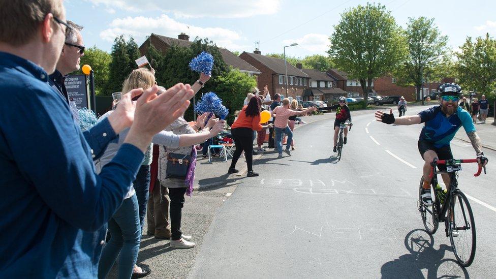 Supporters cheer along cyclists along the route