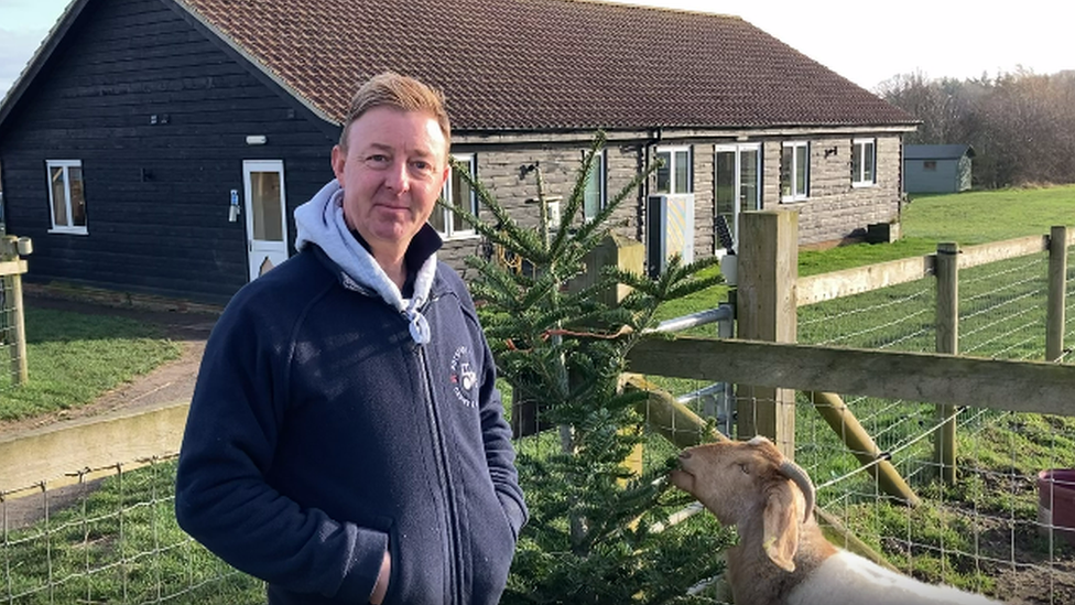 Nathan Nobbs with a goat and a donated tree