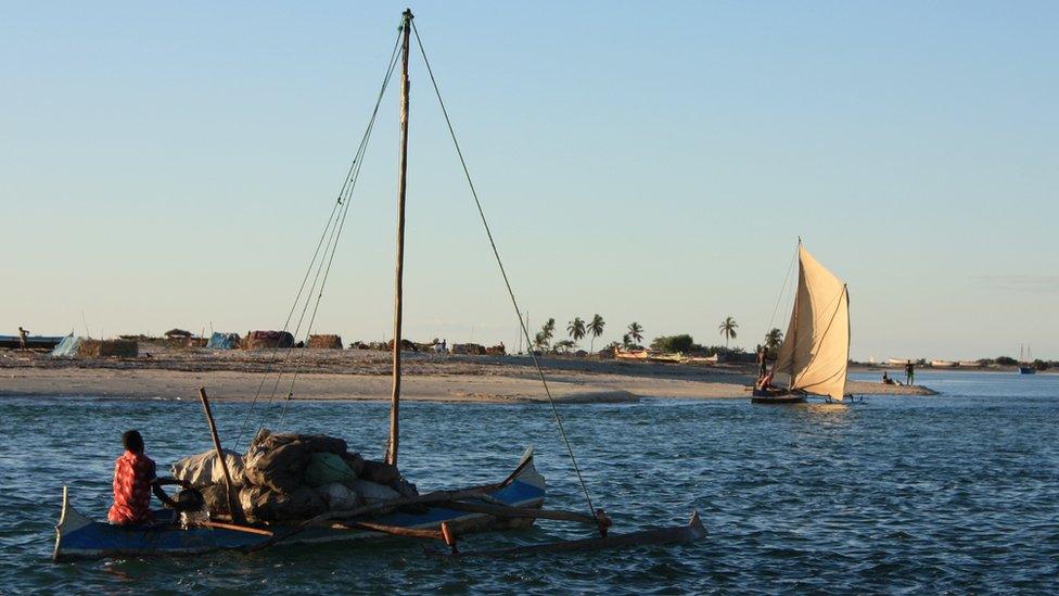 A man sails from Belo-sur-mer on a boat laden with cargo